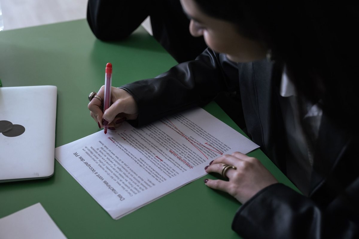 Writer marking edits on a printed document for a Grammarly review